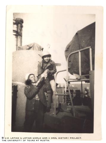 Alvino Mendoza (top) and Bill Ivory (bottom) moving ammo for a five inch gun on the ship's bow. Okinawa, Japan, 1944.
