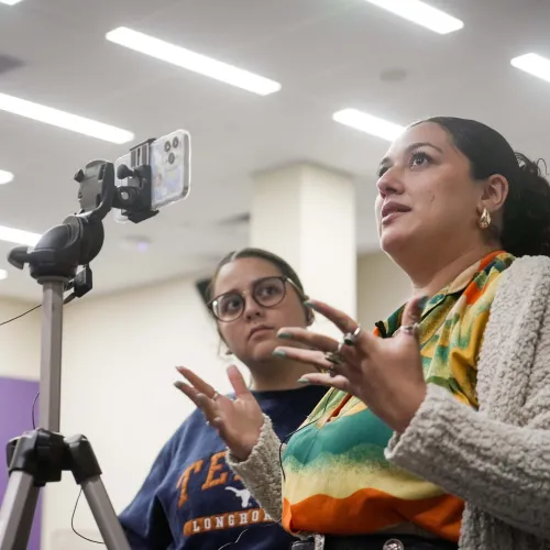 Two Summer Institute participants practicing recording video on an iPhone.